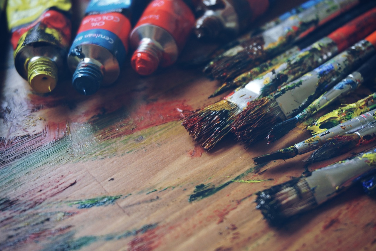 An open art supplies box with pencils and pastels